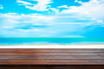 Wood table top on blur white sand beach and blue sky background