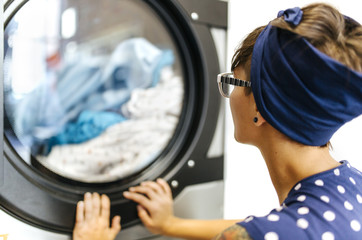 Young woman waiting in a launderette