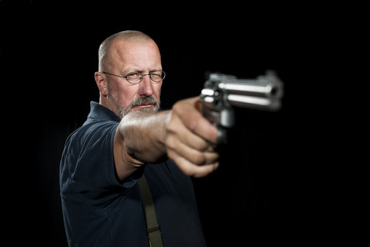 Mature man with revolver aiming