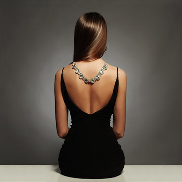 Fototapeta beautiful back of young woman in sexy dress.luxury.sitting Girl with necklace