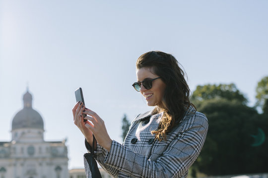 Italy, Vicenza, smiling woman taking a selfie with cell phone
