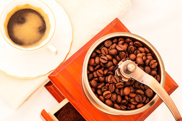 Retro coffee mill and cup of coffee on white backgrownd