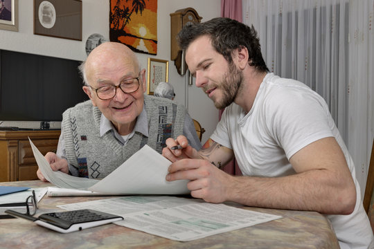 Grandson helping his grandfather by making tax declaration