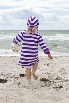 Denmark, Girl playing in sand at beach