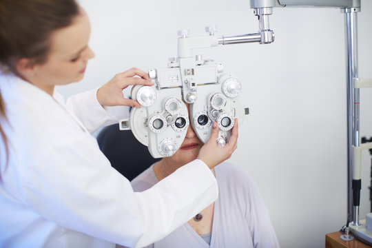 Eye doctor examining senior woman's vision