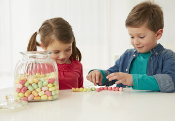 Germany, Munich, Boy and girl with candy jar