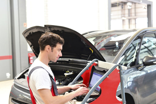 Car mechanic in a workshop using modern diagnostic equipment