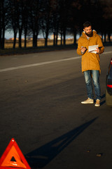 Man examining damaged automobile cars after breaking