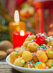 Atmosfera Natalizia con candele, frutta secca e struffoli