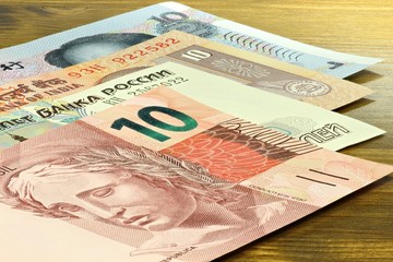 Banknoten der BRIC Staaten auf Holzhintergrund