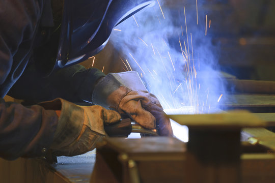 Man welding in a scrap metal recycling plant