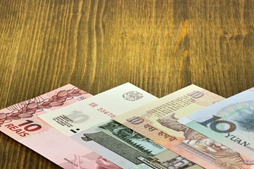 Banknoten der BRIC Staaten auf Holzhintergrund