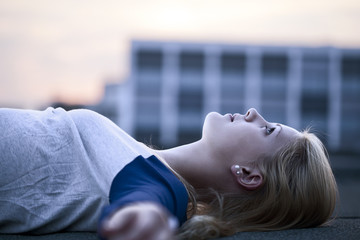 Young woman lying on flat roof