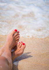 Holiday concept. Woman feet close-up relaxing on beach