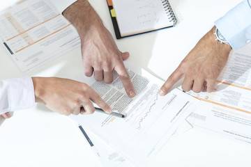 Poland, Warzawa, three hands of businessmen pointing at paper