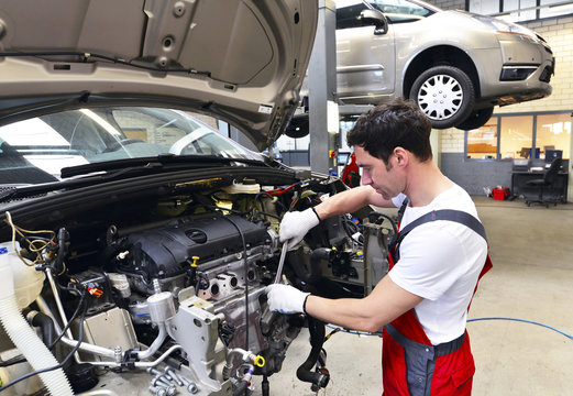 Car mechanic in a workshop working at car