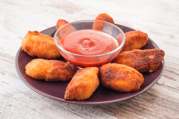 croquettes with salsa bowl on modern wooden base