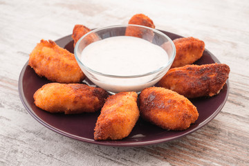 croquettes with salsa bowl on modern wooden base