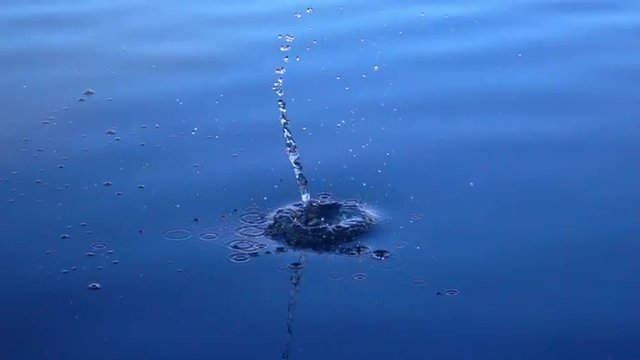 Stone falls into the calm blue water. Beautiful slow motion background with meditative effect. Full HD footage 1920x1080.
