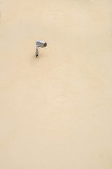 Security camera on yellow wall