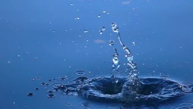 Great close up scene with two stones fall into the calm blue water. Excellent moving background with meditative effect. Slow motion. Relaxing view of the calm water. Full HD footage 1920x1080.
