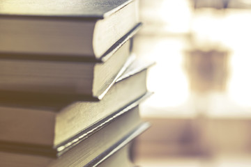 Stack of hardcover books on top of a desk