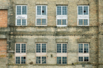 Fototapeta premium Facade of old industrial building of beige brick with windows.