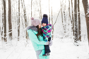 Fototapeta na wymiar happy family mother and child baby daughter on a winter walk in the woods