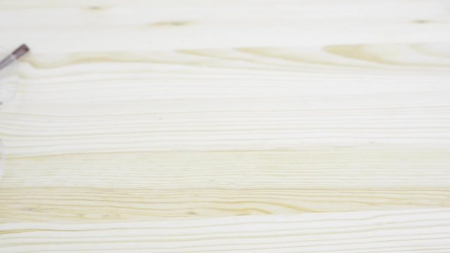 Office desk background banner. Modern glasses on empty wooden desktop.