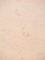 Close up of footprints on the beach sand at the sunset