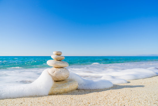 Stones pyramid on sand symbolizing zen, harmony, balance. Ocean