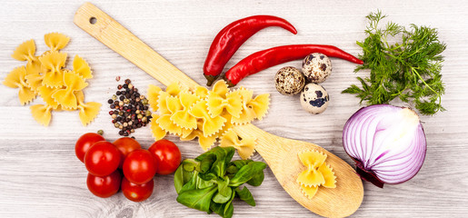 raw pasta with fresh vegetables, greens and spices