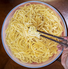 Homemade noodle with hand, abstract background.