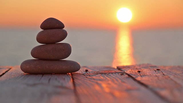 Stacked pebbles and setting sun