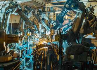 Fototapeta na wymiar Welding robots movement in a car factory