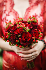 bride holding her red wedding bouquet of flowers