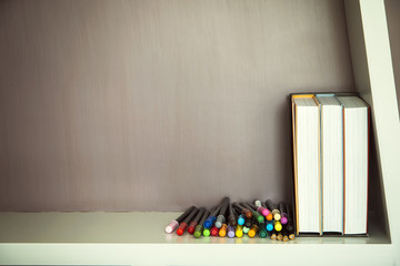 Colorful pen and books on shelve