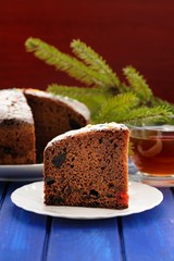 Chocolate christmas fruit cake and fur brunch on blue table
