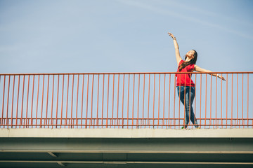Fototapeta na wymiar Girl on bridge in city.