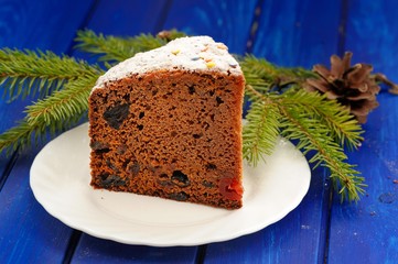 Chocolate christmas fruit cake, fur brunch and cone on blue tabl