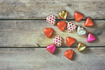 top view image of colorful heart shape chocolates on wooden table. valentine's day celebration concept

