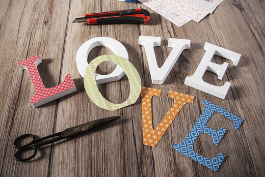 Decorating wooden LOVE letters with vintage papers