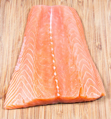 Fresh salmon fillet on a wooden background. Sources of omega 3 fatty acids.
