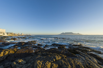 Cape Town Table Mountain's iconic flat top seen from Blouberg Strand in South Africa during sunset.