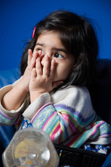 Baby girl sitting in her room with hands on her face. Focus on Hands