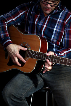 Mann spielt Gitarre,schwarzer Hintergrund