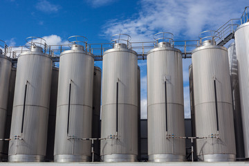 Giant industrial tanks on the bright blue sky