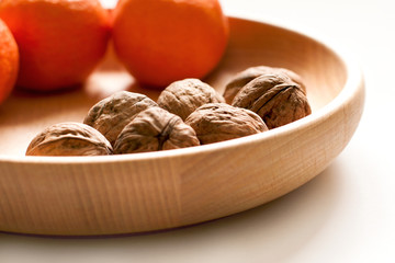 Several whole walnuts in wooden bowl