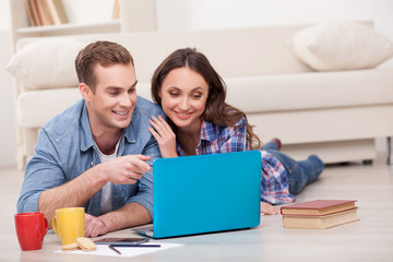 Attractive married couple is using notebook at home