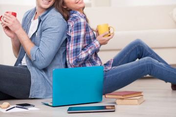 Beautiful loving couple with tea and laptop